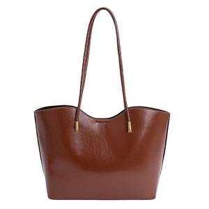 Détail du sac cabas marron brillant avec bordure ondulée et ferrures dorées