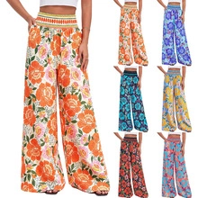 Detail view of high waisted floral wide leg trousers with colorful ethnic patterns