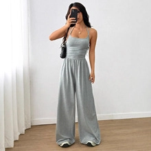 Detail of grey halter neck jumpsuit with cinched waist and wide leg silhouette