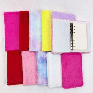Platliggende weergave van kleurrijke pluche A7-minibinders met 6-rings metalen clips en bont