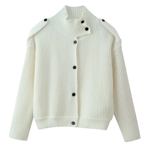 Detail of loose-knit cardigan featuring vertical ribbing, stand collar, and black buttons