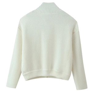 Detail of cream white oversized rib-knit sweater showing thick texture and stand collar