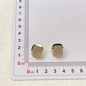 Dettaglio di un orecchino a bottone quadrato da 1,5 cm con intarsio glitterato rosa
