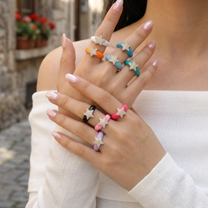 Close-up of colorful enamel star rings with cubic zirconia inlay worn by model