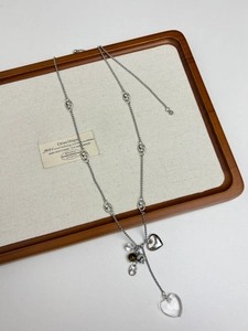 Detail of silver long chain necklace featuring double heart pendants and natural stone beads