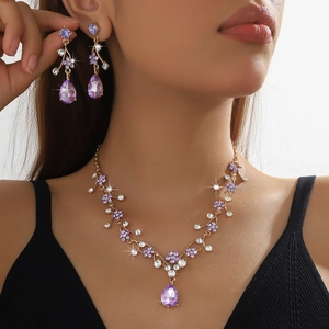 Golden bridal jewelry set with purple rhinestones and waterdrop gems on elegant model