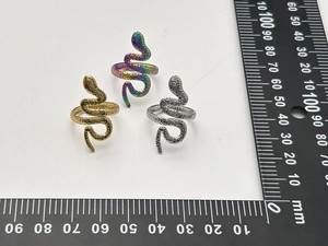 Détail macro de bagues serpent en or, argent et arc-en-ciel avec texture martelée élégante