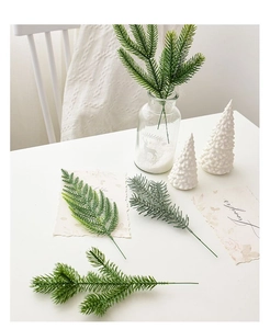 Detailed view of artificial green pine needles in glass vase for Christmas home decor