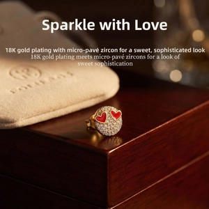 Detail of 18K gold-plated stud earring with micro-pave zircons and red enamel hearts