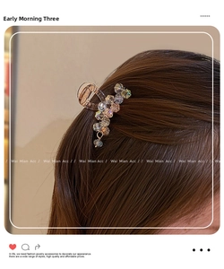 Detail view of a mini claw clip with pastel crystals and bead pendant in hair