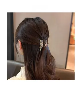 Elegant champagne gold hair claw clip with brown crystals worn on a half-up hairstyle