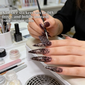 Détail d'autocollants en dentelle noire appliqués sur de longs ongles stiletto