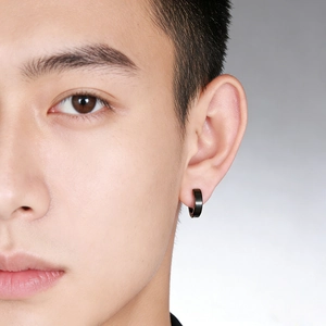 Close-up of a black stainless steel hoop earring worn by a male model for a punk look