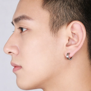 Close-up of minimalist silver stainless steel hoop earring worn on model's ear
