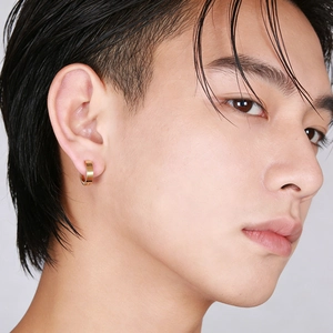 Close-up of men's gold titanium hoop earring with brushed texture finish on male model