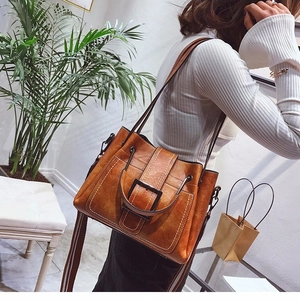 Vintage brown leather tote bag with decorative buckle and contrast stitching for women