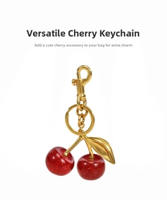 Detail of red glitter cherry keychain with golden metal leaves and lobster clasp