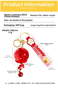 Detailed view of red glow-in-the-dark wind chime keychain with honey strap and sequins