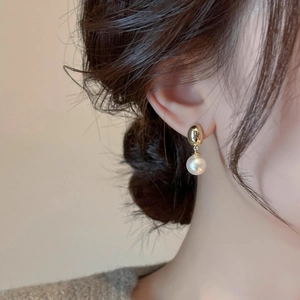 Elegant French vintage gold oval stud earrings with white round pearls on model