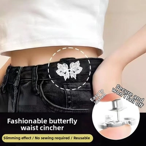 Detail of silver butterfly waist buckle showing the pin fastener and back clasp on denim