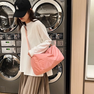 Grande borsa sportiva rosa in nylon da donna indossata da una modella casual