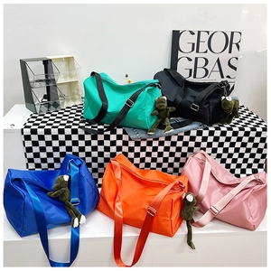 Cinque grandi borse da viaggio in nylon colorato con ciondoli rana su sfondo di design