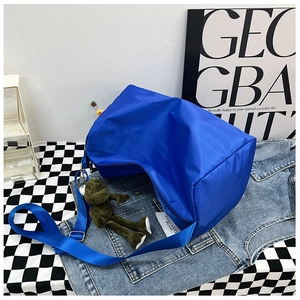 Borsa a mezzaluna in nylon blu con ciondolo a rana verde e tracolla larga regolabile