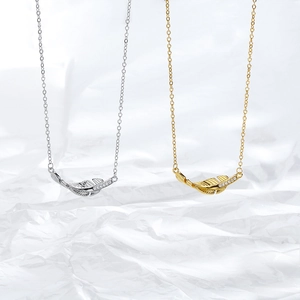 Detailed view of feather pendants in gold and silver with zircon stones on O-chain