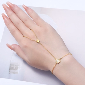 Elegant gold-tone star slave bracelet set with zircon stones on a female hand