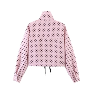 Detailansicht der Rückseite einer rosa gepunkteten Jacke mit Stehkragen und Kordelzug