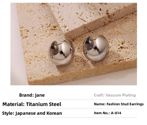 Macro view of polished silver hollow spherical earrings on textured stone surface