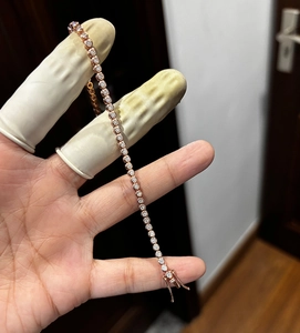 Detail of rose gold tennis bracelet featuring small round cut stones and secure clasp