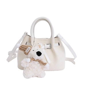 White leather bucket bag with cute bear pendant, stylish crossbody handbag for women.