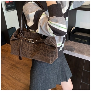 Dettaglio della grande borsa tote leopardata con manici scuri e fibbia in metallo decorativa