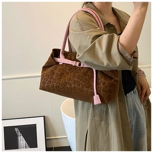 Dettaglio della borsa tote leopardata con tracolla rosa e anelli dorati in interni