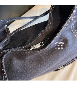 Gros plan sur la fermeture éclair en métal argenté d'un sac à main en denim bleu foncé