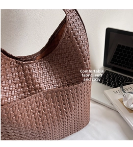 Vue détaillée du sac Hobo tressé à côté d'un ordinateur dans un cadre de vie de bureau