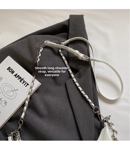 Close-up of white leather-woven silver metal chain strap with adjustable buckle clasp