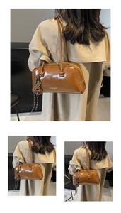 Detailed view of vintage brown tote bag worn on shoulder over classic beige trench coat