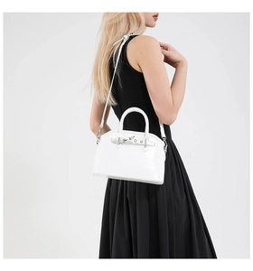 Detailed side view of a white shell handbag on model showing strap and silver hardware