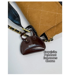 Detail of brown quilted suede shoulder bag with gold chain and Muting mini pouch charm