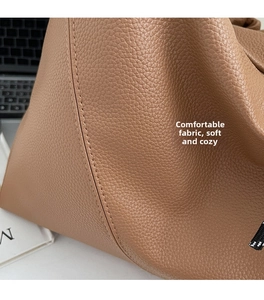 Gros plan sur la texture du cuir grainé marron caramel et coutures d'un grand cabas