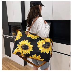 Detail of sunflower print travel bag showing large capacity and adjustable shoulder strap