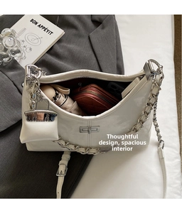 Detail view of white patent leather hobo bag showing spacious interior with maroon lining