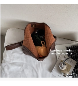 Vue macro de l'intérieur spacieux d'un sac cabas tressé marron foncé avec essentiels