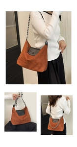 Detail of caramel suede tote bag with black leather flap and silver chain strap