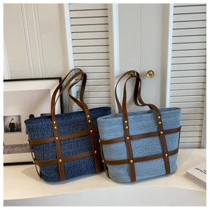 Detail of denim tote bags with leather grid patterns and decorative gold studs