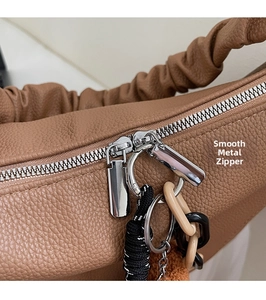 Détails des doubles fermetures éclair argentées sur sac cabas en cuir grainé marron