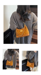 Close-up of brown quilted suede shoulder bag with gold chain and metal twist lock
