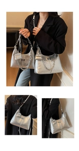 Detail of silver pleated shoulder bag featuring metallic chain and small pouch attachment